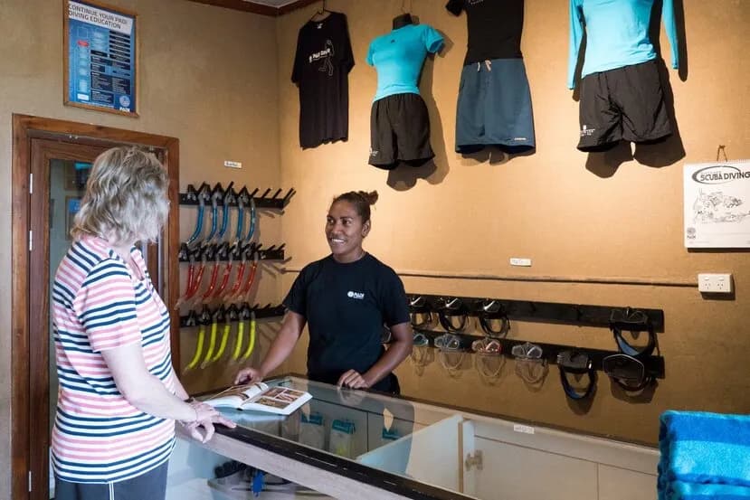 A team member helps a guest at the Paradise Taveuni dive center