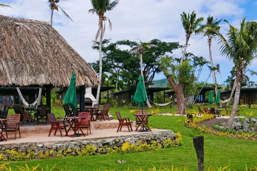 An outdoor seating area with tables and chairs and hammocks