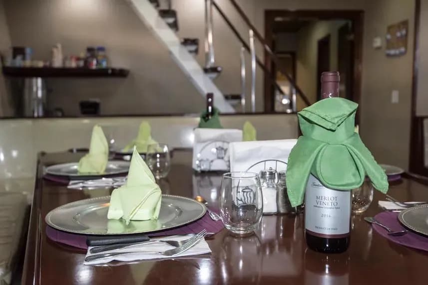 A dining table on the Rocio del Mar Liveaboard, set with wine glasses and neatly arranged napkins.