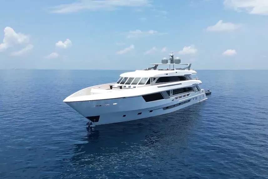 Ariyal Liveaboard yacht sailing in the middle of the vast ocean under a clear blue sky.