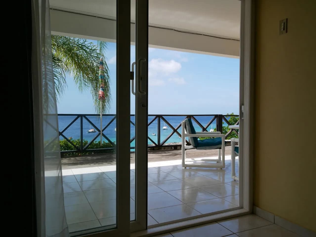 A door opens to a balcony overlooking the pristine sea.